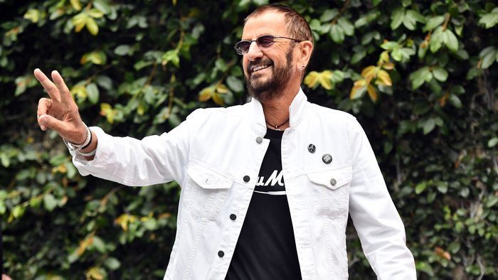 Ringo Starr smiles and holds up two fingers