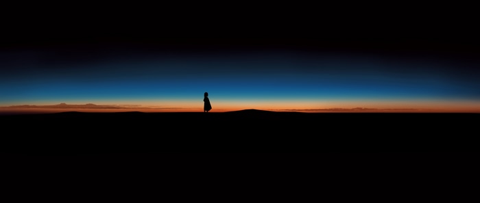 Silhouette of a person against a sunset sky
