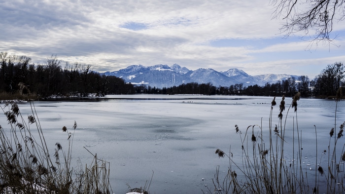 Frozen lake with snow-capped mountains in the background