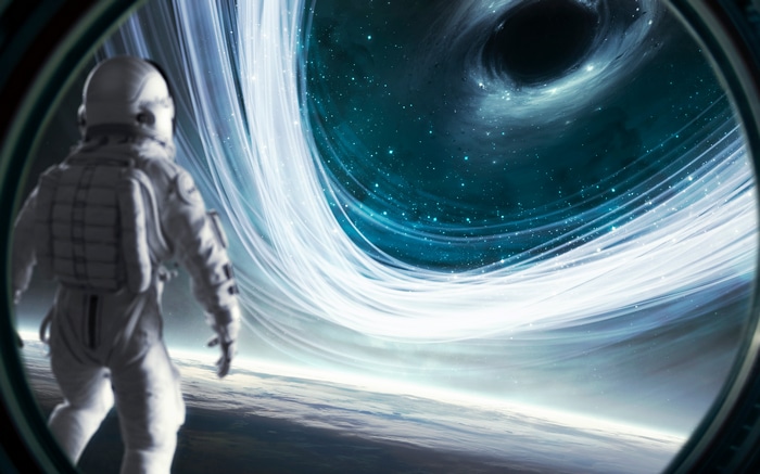 Astronaut looking at a black hole and galaxy