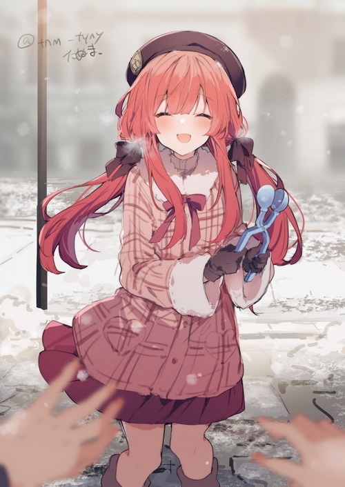 Girl in winter hat and coat holding snowball maker