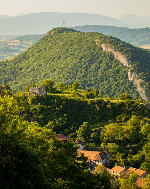 Green mountain with ruins and village below