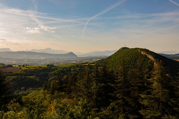 Green forested hills and mountains under a blue sky