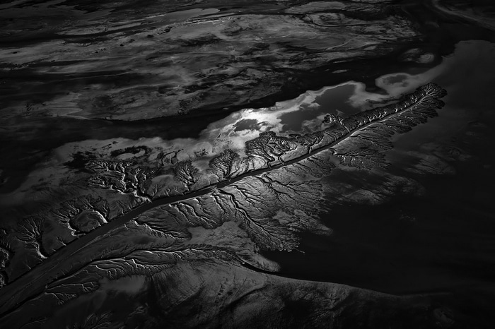 Aerial view of a river delta with clouds and reflection