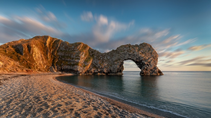 4K sunset over Durdle Door rock arch and beach