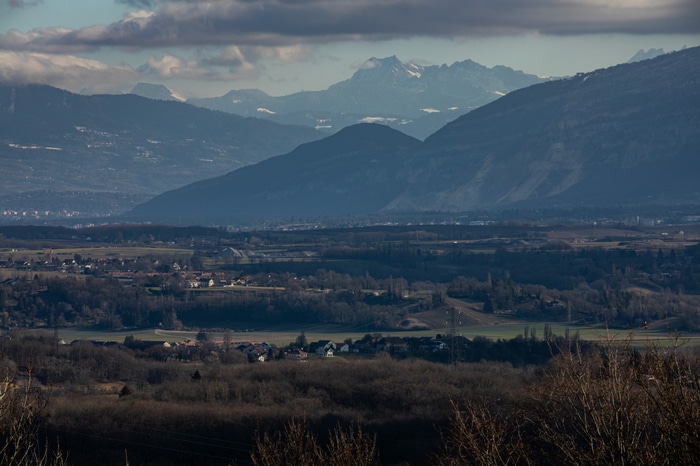Mountains village and forest landscape under cloudy sky