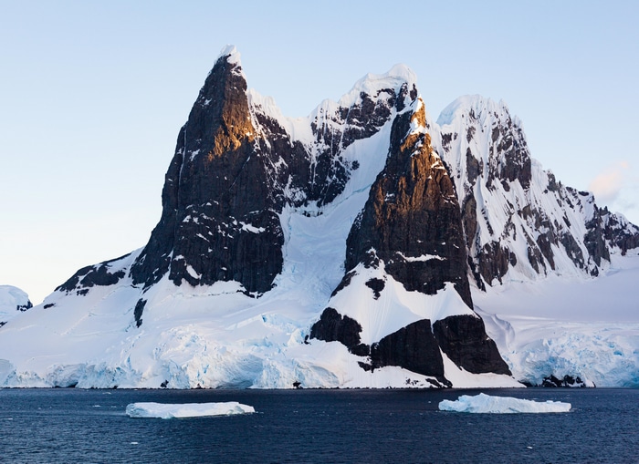 Antarctic mountains with icebergs in the ocean