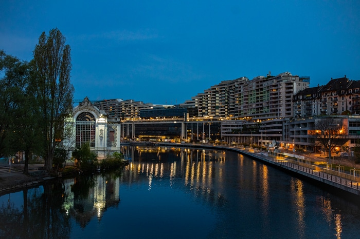 City buildings and a river at dusk with reflections