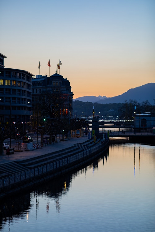 Cityscape with river and mountains at twilight