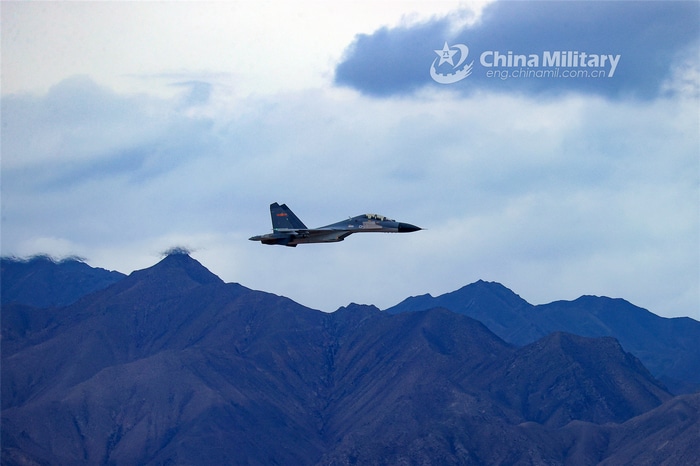 Chinese military jet fighter flying over mountains