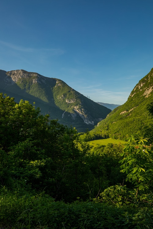 Green valley between mountains under a clear blue sky