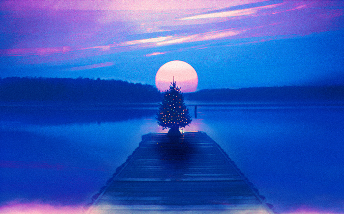 Christmas tree on a dock at sunset with a large sun