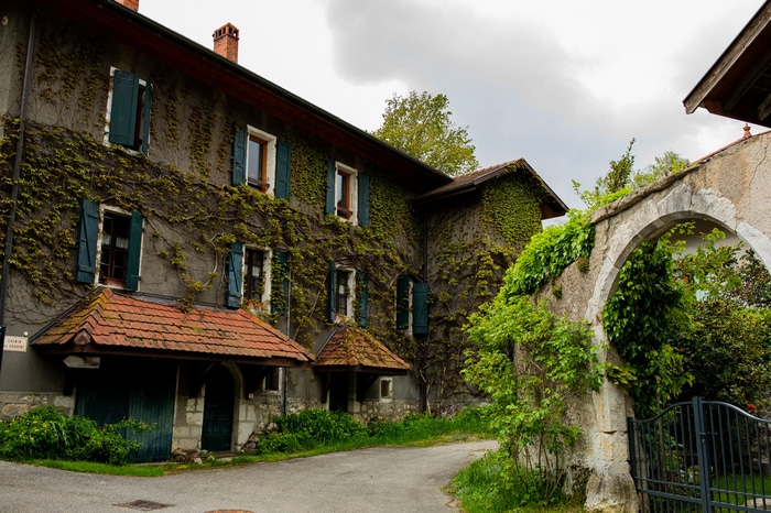 Ivy-covered house with arched stone entrance and gate