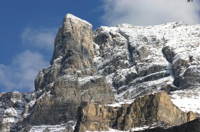 Snow-covered rocky mountains under a blue sky