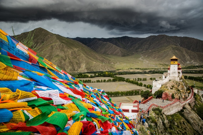 Tibetan monastery with prayer flags and mountains