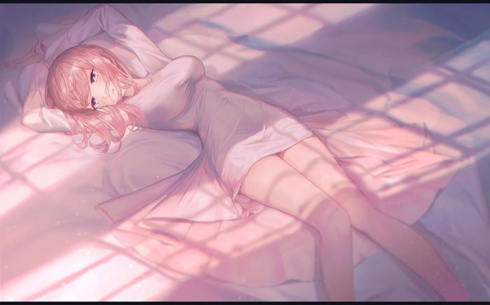 Woman lying on bed with pink hair