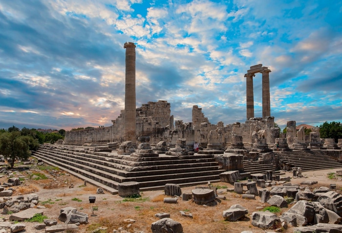 Ancient ruins of a temple with columns under a cloudy sky