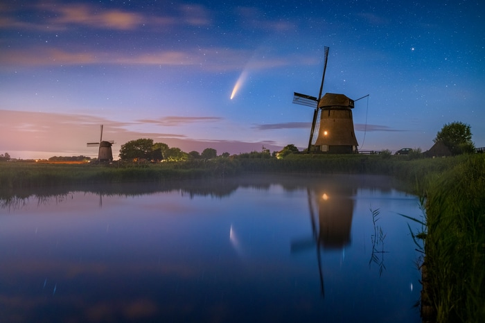 Comet over Dutch windmills at night