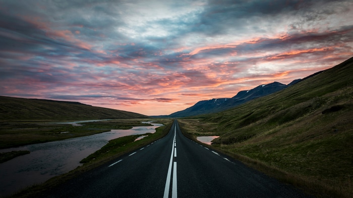Road through Iceland landscape at sunset