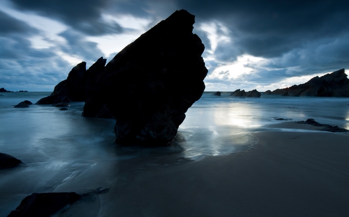 Monochrome beach with rocks and stormy clouds