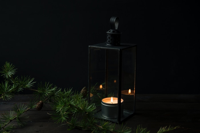Lantern with candle and pine needles