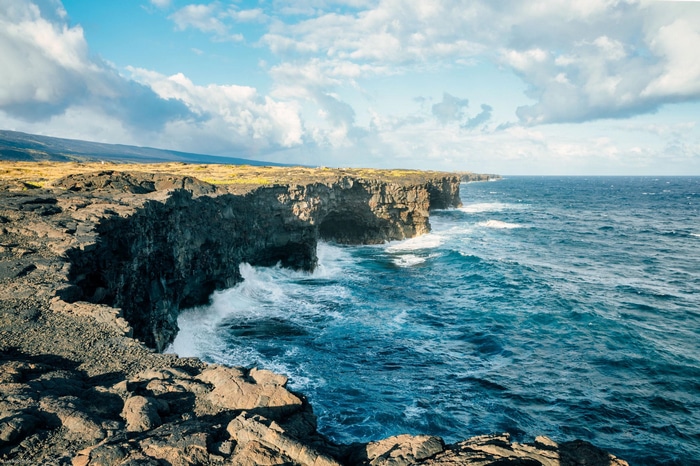 Ocean waves crash against volcanic cliffs in Hawaii