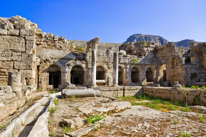 Ancient ruins in Corinthia, Greece under a clear blue sky.