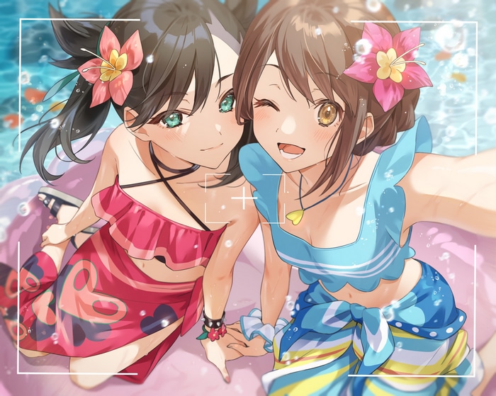 Two girls in swimwear taking a selfie in the water
