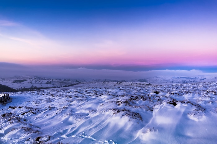 Snowy landscape with colorful sky at dusk