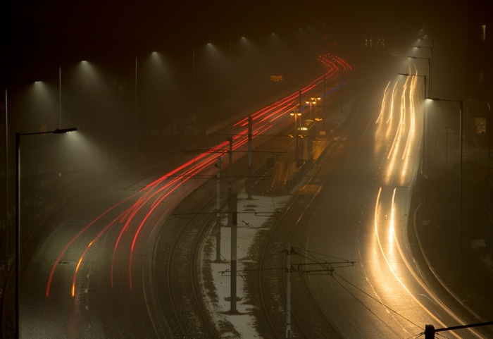 Long exposure of car lights on a misty road at night