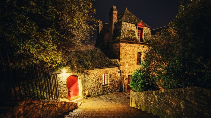 Stone building with red doors at night in France