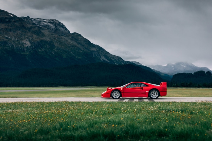 Red Ferrari F40 on a road with mountains