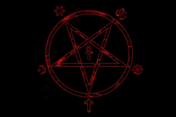Red pentagram with occult symbols on black background