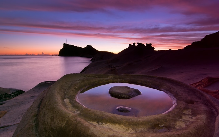 Rocky coastline at sunset with calm water