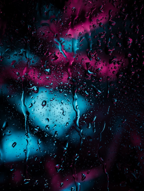 Raindrops on glass with neon lights