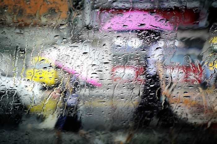 People with umbrellas in the rain on a street