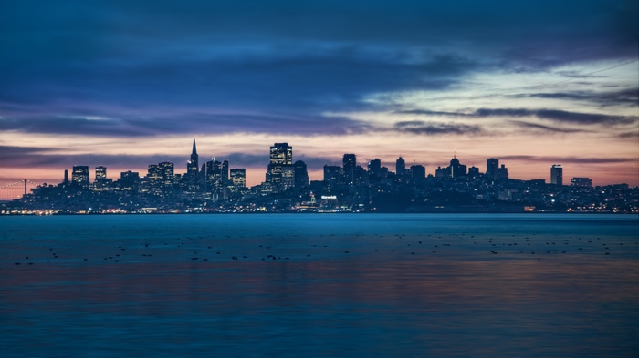 San Francisco skyline at sunset with clouds and water