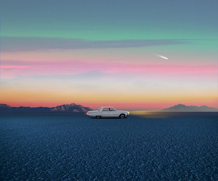 White car driving on a salt flat at sunset