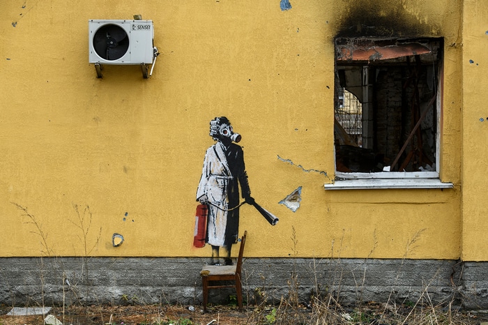 Banksy mural of a person with gas mask and fire extinguisher in Ukraine