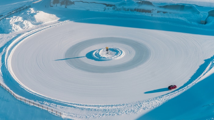 Car driving on a snowy circle in New Zealand