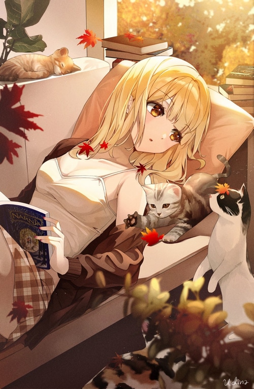 Girl reading The Chronicles of Narnia with cats