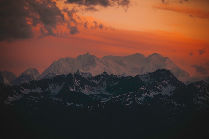 4K snowy mountains at sunset with clouds