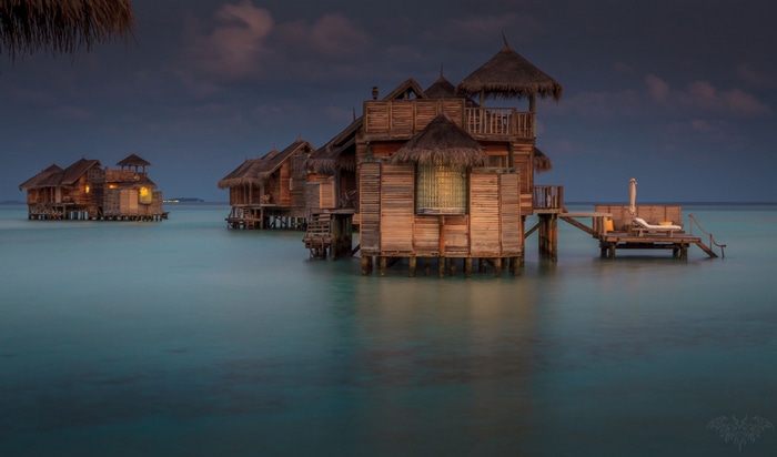 Overwater bungalows in the ocean at dusk