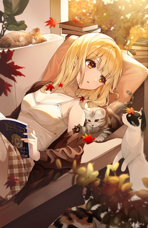 Girl reading with cats and autumn leaves