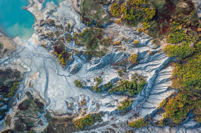 Aerial view of a barren landscape with a turquoise lake