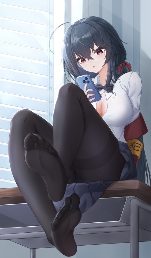 Schoolgirl in uniform with phone in classroom