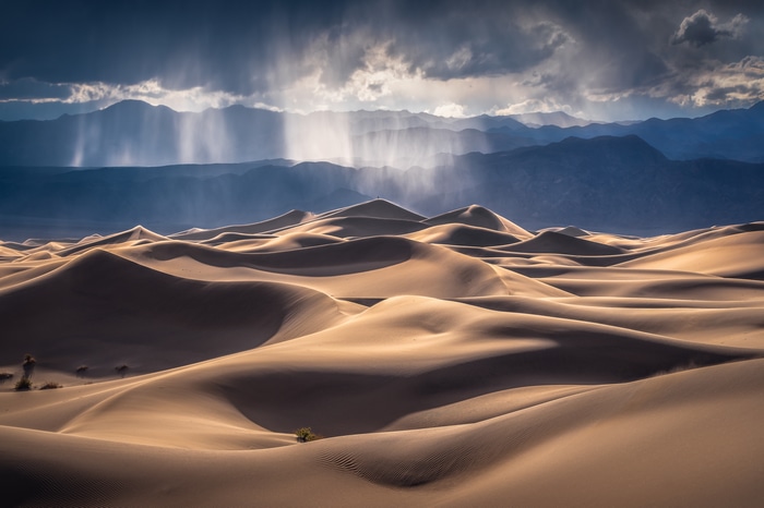 Death Valley sand dunes with rain and mountains