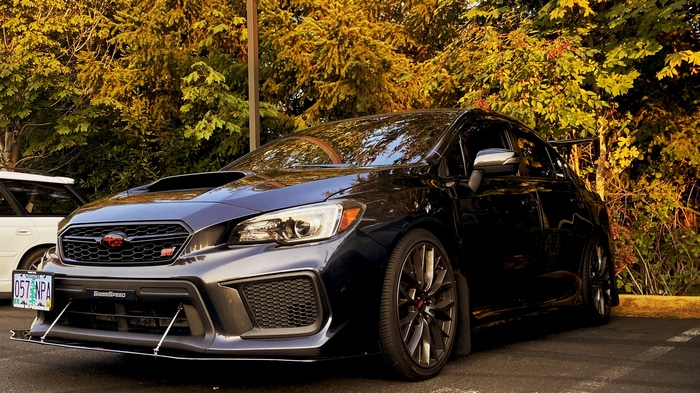 Dark Subaru WRX STI parked near trees