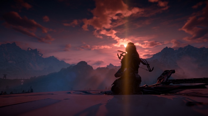 Aloy kneeling at sunset in Horizon Zero Dawn