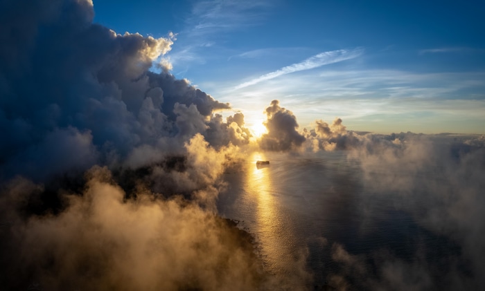 Sunrise over the sea with clouds and a ship